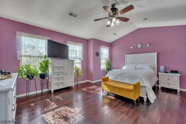 a spacious bedroom with a bed and a flat screen tv