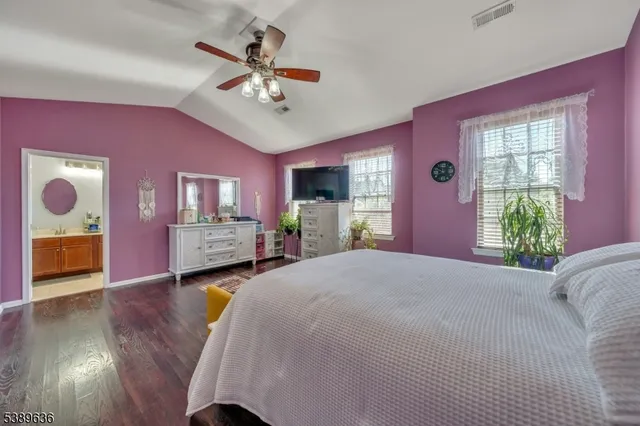 a spacious bedroom with a bed and a chandelier