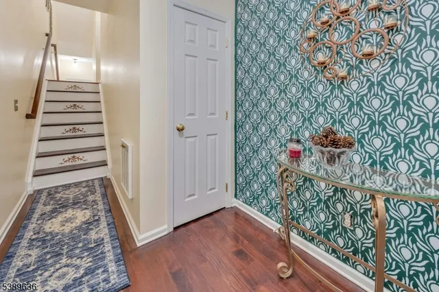 a view of a hallway with wooden floor and stairs