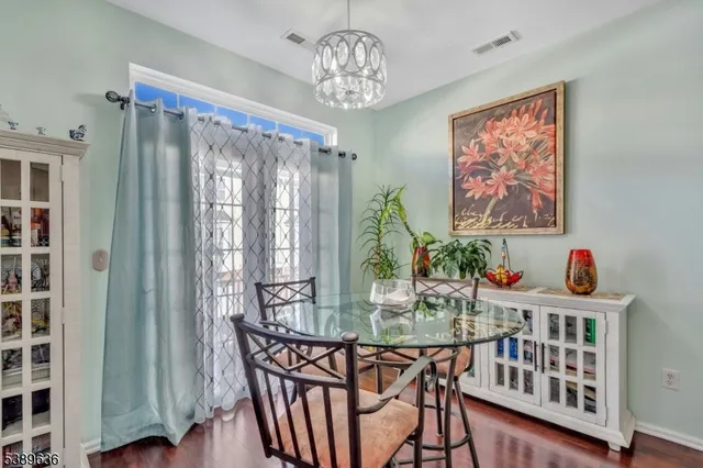 a dining room with furniture a chandelier and wooden floor