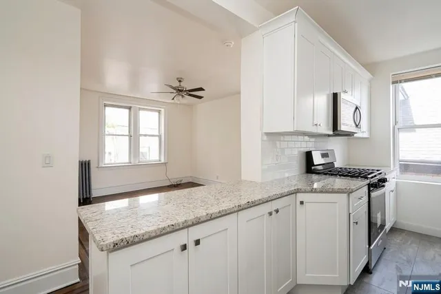 a kitchen with stainless steel appliances granite countertop a sink a stove and cabinets