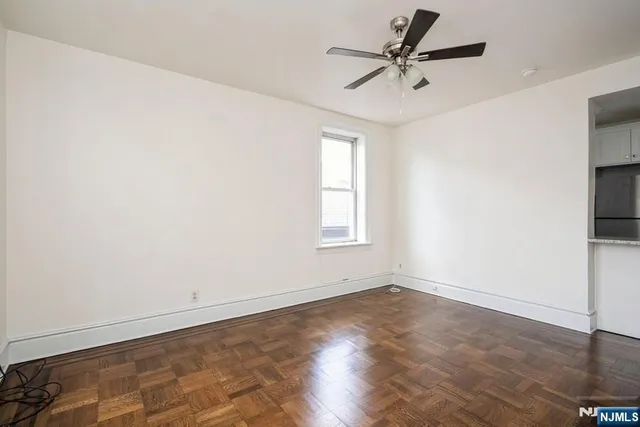 an empty room with a window and a ceiling fan