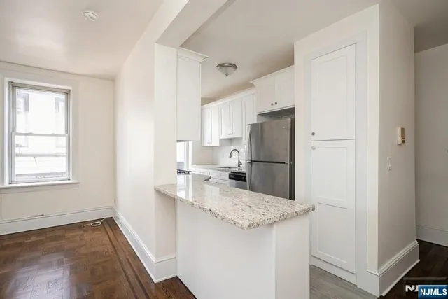 a kitchen with granite countertop a refrigerator and a sink