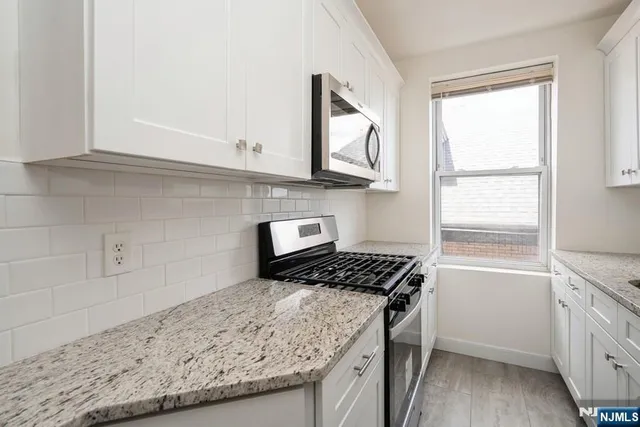 a kitchen with granite countertop a sink and a stove