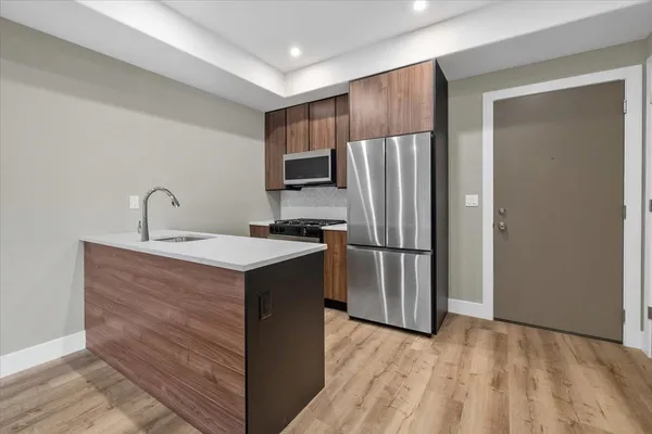 a kitchen with stainless steel appliances a refrigerator and a sink