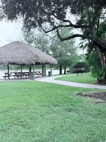 a view of a big yard with potted plants and large trees