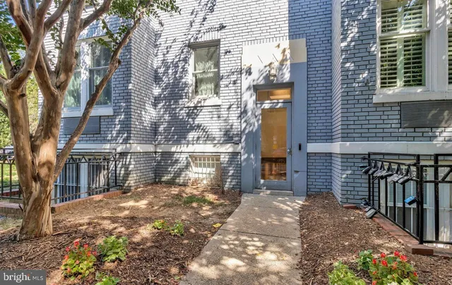 a view of a house with brick wall and potted plants