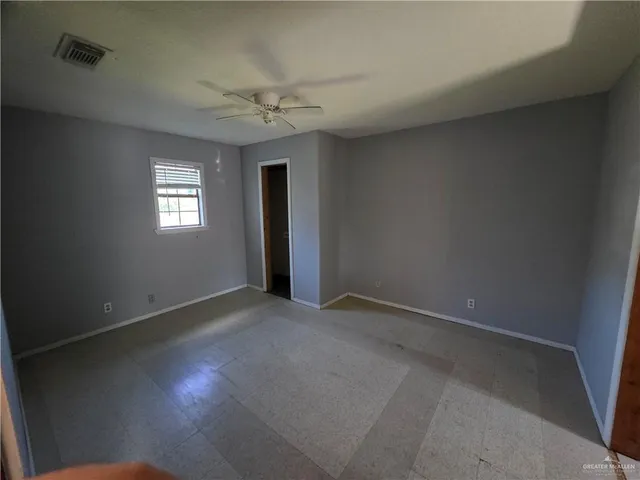 an empty room with windows and closet