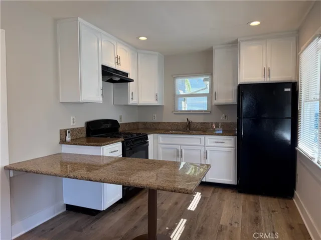 a kitchen with a refrigerator and a stove top oven