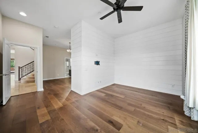 a view of empty room with wooden floor and window