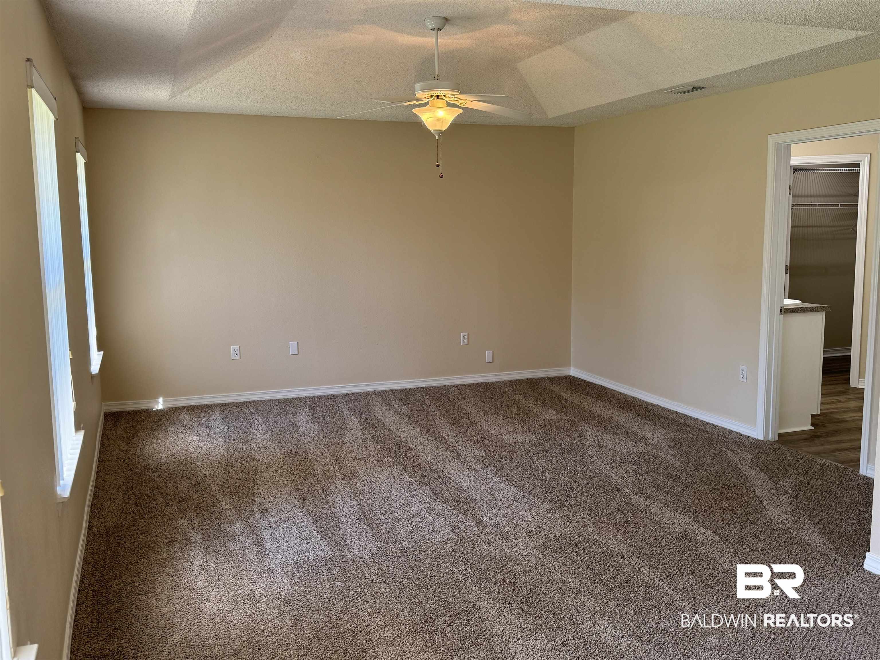 32769 Arbor Ridge Circle Lillian, AL 36549 - Photo 13 of 36 Carpeted spare room with ceiling fan, a textured ceiling, and lofted ceiling