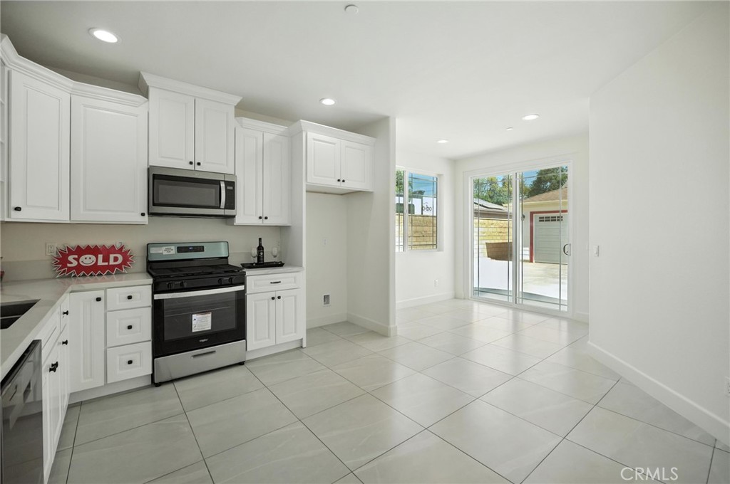 5151 Peony Court Riverside, CA 92506 - Photo 7 of 23 a kitchen with granite countertop a stove top oven and cabinets