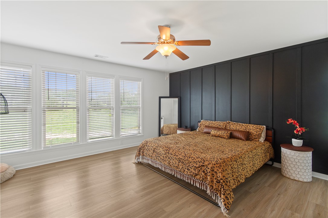 2900 Highway 187 Anderson, SC 29626 - Photo 21 of 41 A chic bedroom features sleek flooring and an accent wall, complemented by abundant natural light.