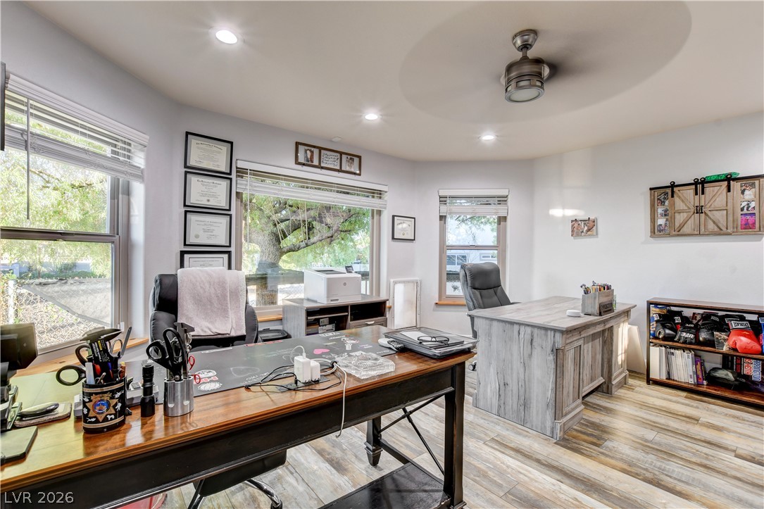6460 Racel Street Las Vegas, NV 89131 - Photo 50 of 59 Generous windows frame serene backyard views in this wood-floored home office workspace.