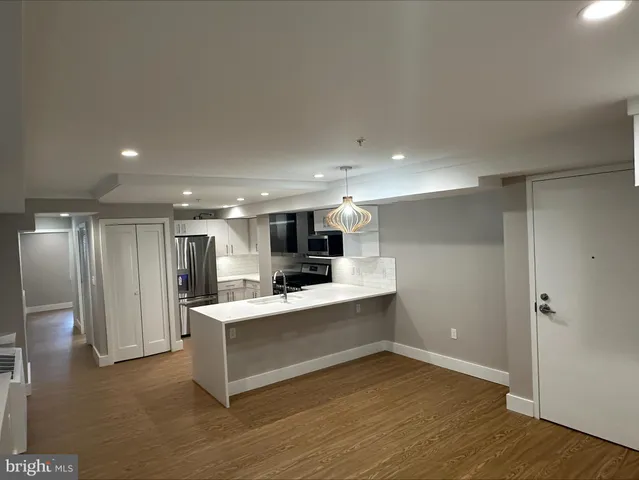 a view of kitchen with sink refrigerator and wooden floor
