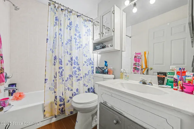 a bathroom with a sink a toilet and shower curtain