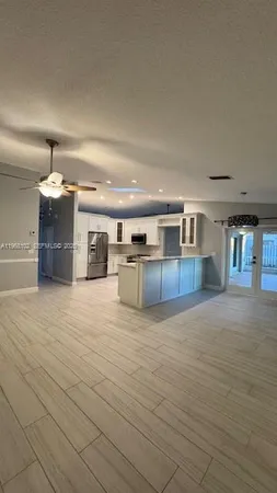a large kitchen with stainless steel appliances kitchen island granite countertop a sink and cabinets