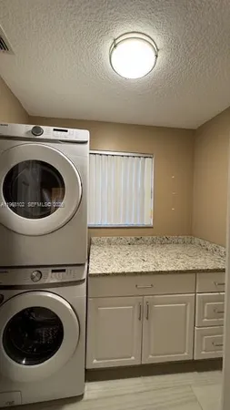 a utility room with sink dryer and washer
