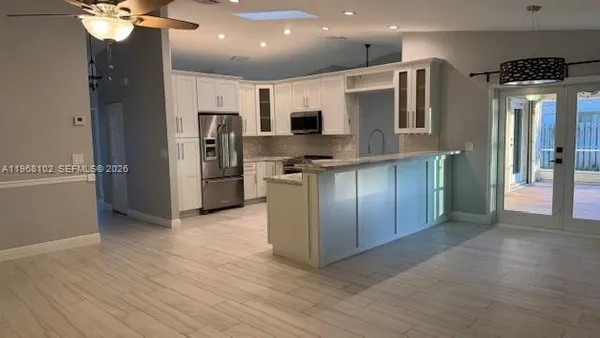 a kitchen with stainless steel appliances granite countertop a refrigerator and a stove top oven