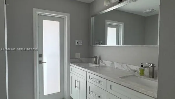 a bathroom with a granite countertop sink and a mirror