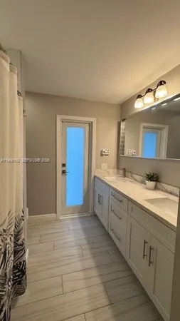 a spacious bathroom with a double vanity sink and a mirror