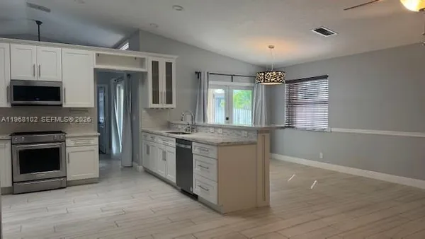 a large kitchen with granite countertop a stove and a sink