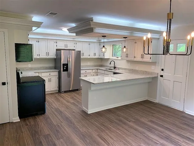a kitchen with a refrigerator sink and cabinets
