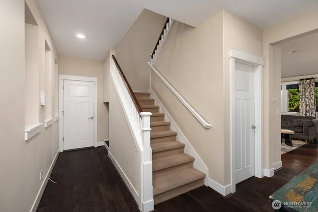 a view of a hallway with wooden floor and stairs