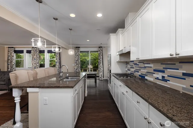 a kitchen with kitchen island granite countertop lots of counter space and a sink