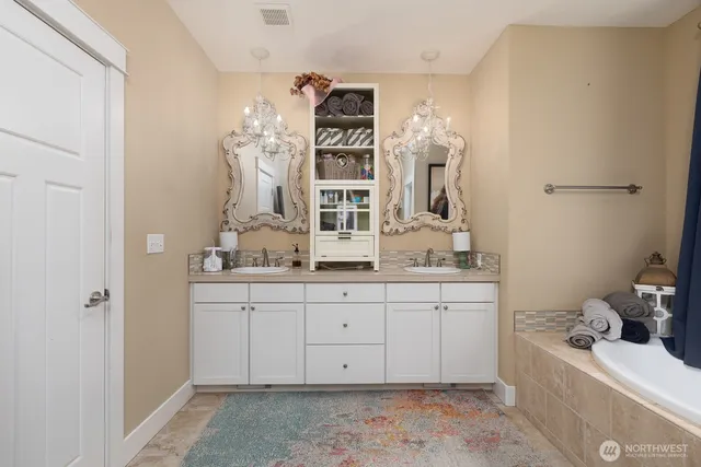 a spacious bathroom with double vanity and mirrors