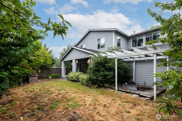 a front view of house with yard and trees in the background