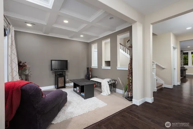 a living room with furniture a wooden floor and a flat screen tv