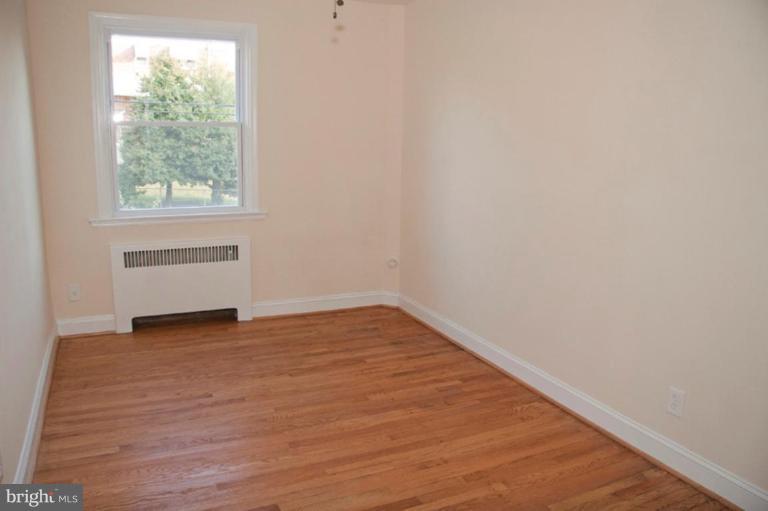 1538 Northgate Road Baltimore, MD 21218 - Photo 21 of 30 a view of an empty room with wooden floor and a window