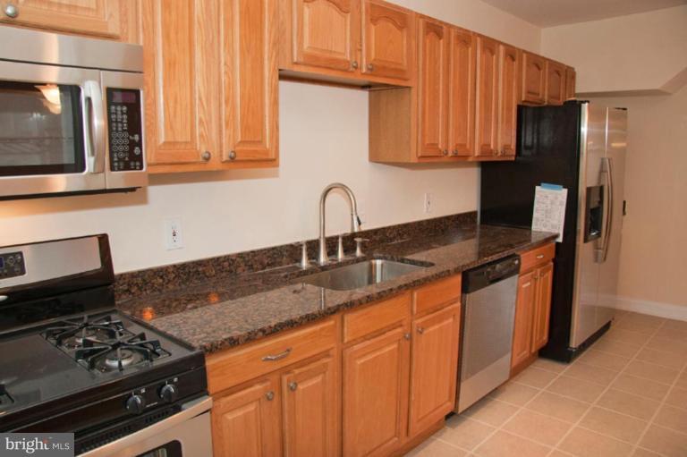 1538 Northgate Road Baltimore, MD 21218 - Photo 9 of 30 a kitchen with stainless steel appliances granite countertop a sink stove and refrigerator