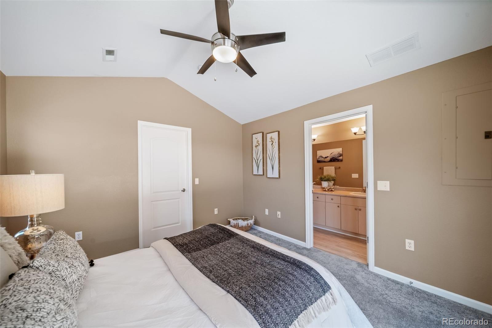 8626 Gold Peak Drive, Unit B Highlands Ranch, CO 80130 - Photo 14 of 40 a bedroom with a bed and a lamp