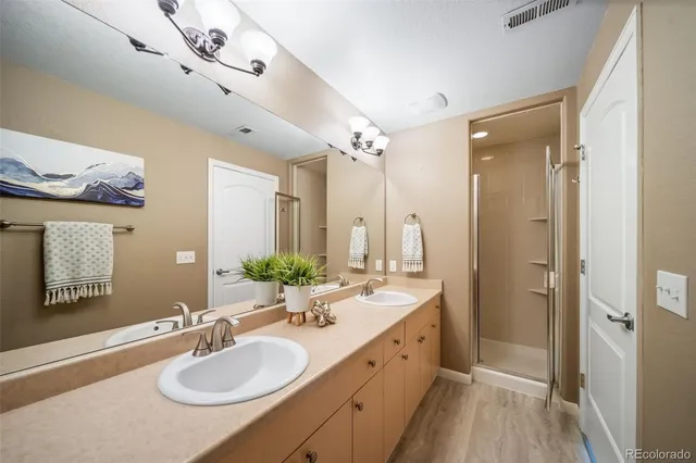 a bathroom with a granite countertop sink a mirror and a shower