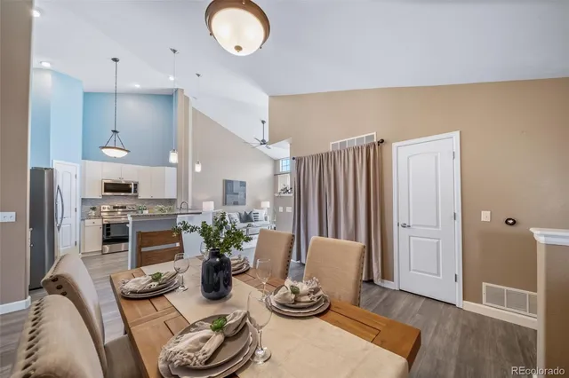 a kitchen with stainless steel appliances granite countertop a refrigerator and a wooden floor