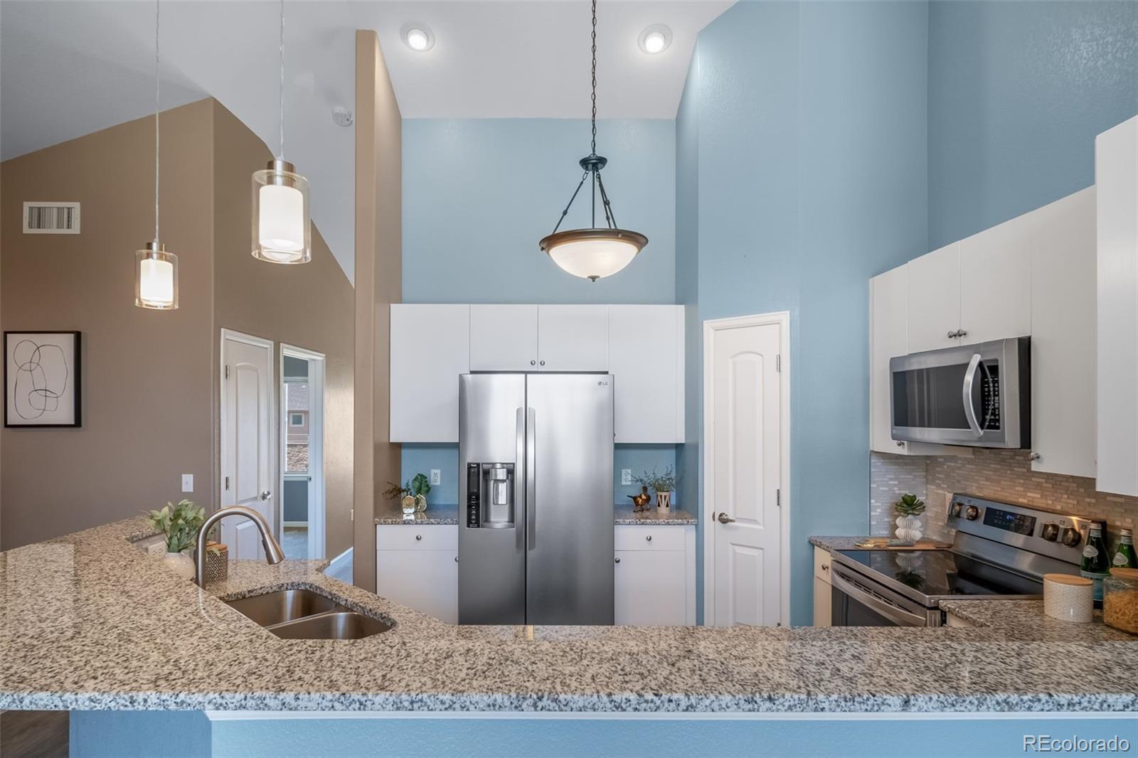 8626 Gold Peak Drive, Unit B Highlands Ranch, CO 80130 - Photo 10 of 40 a kitchen with stainless steel appliances granite countertop a sink refrigerator and microwave