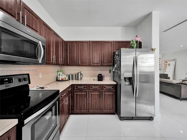 a kitchen with stainless steel appliances granite countertop a stove refrigerator and microwave
