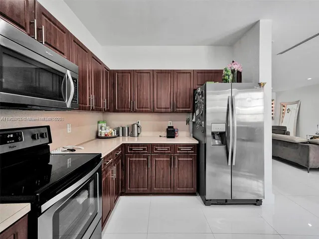 a kitchen with stainless steel appliances granite countertop a stove refrigerator and microwave