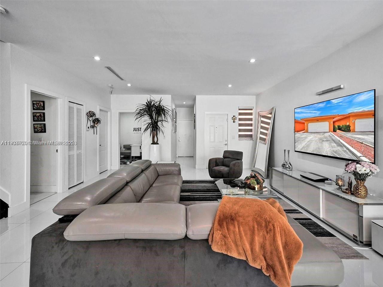 7565 Northwest 177th Terrace, Unit 7565 Hialeah, FL 33015 - Photo 2 of 35 a living room with furniture and a flat screen tv