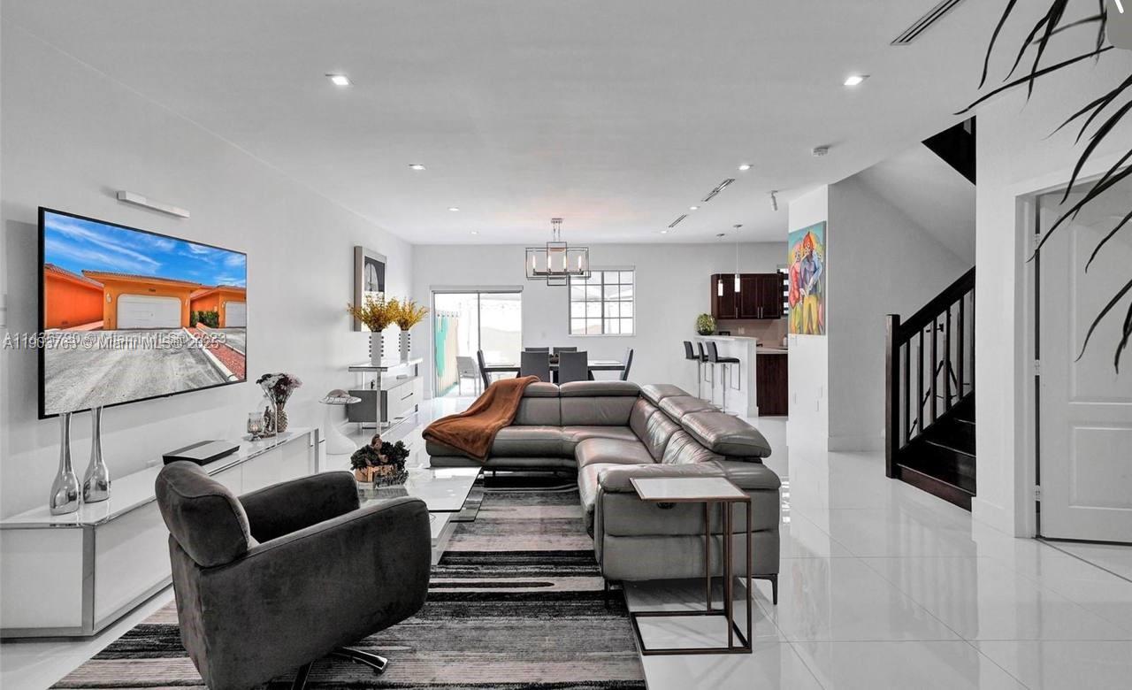 7565 Northwest 177th Terrace, Unit 7565 Hialeah, FL 33015 - Photo 22 of 35 a living room with furniture and a flat screen tv