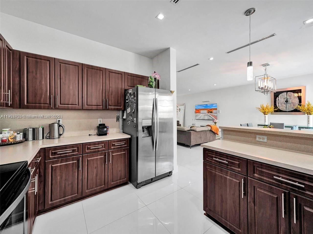 7565 Northwest 177th Terrace, Unit 7565 Hialeah, FL 33015 - Photo 24 of 35 a kitchen with stainless steel appliances granite countertop a sink stove and refrigerator