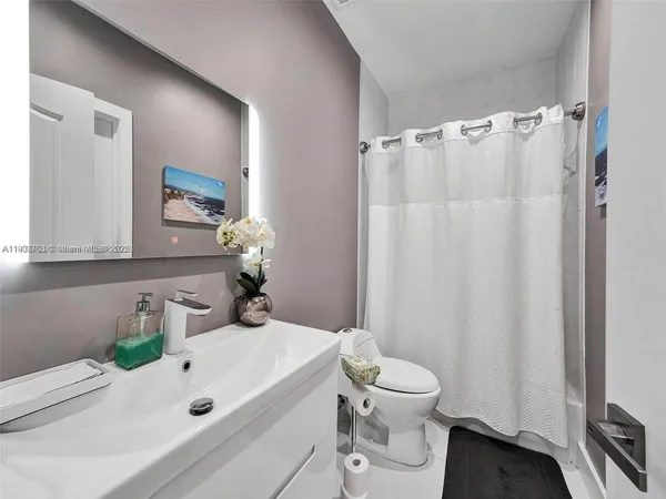 a bathroom with a sink a toilet and a mirror