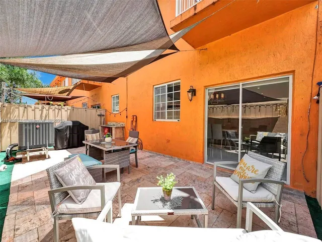 a outdoor space with the couches and dining table with the view of the back