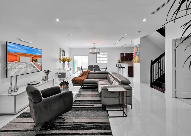 a living room with furniture kitchen view and a window