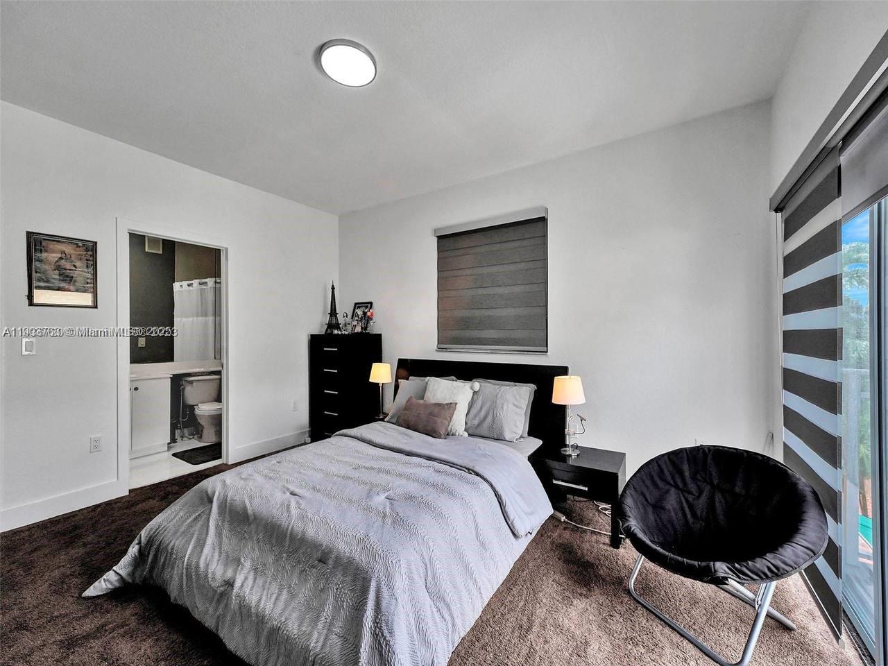 7565 Northwest 177th Terrace, Unit 7565 Hialeah, FL 33015 - Photo 10 of 35 a bedroom with a bed and cabinets