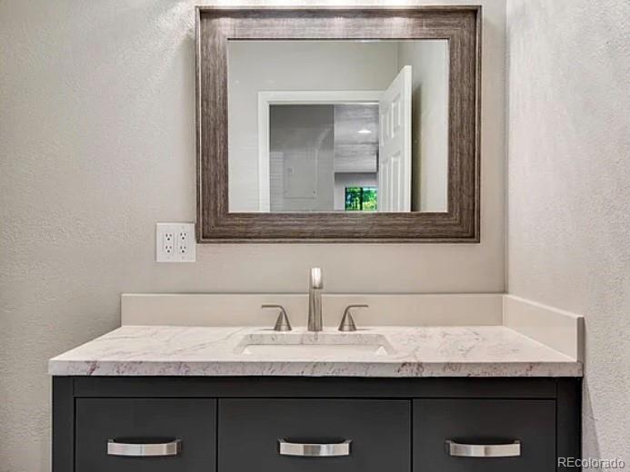 1600 Yates Street Denver, CO 80204 - Photo 8 of 20 a bathroom with a granite countertop sink a toilet and mirror
