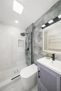 a bathroom with a sink mirror toilet and shower