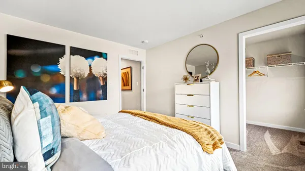 a bedroom with a bed and a flat tv screen on dresser